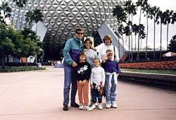 the family poses in front of Spaceship Earth